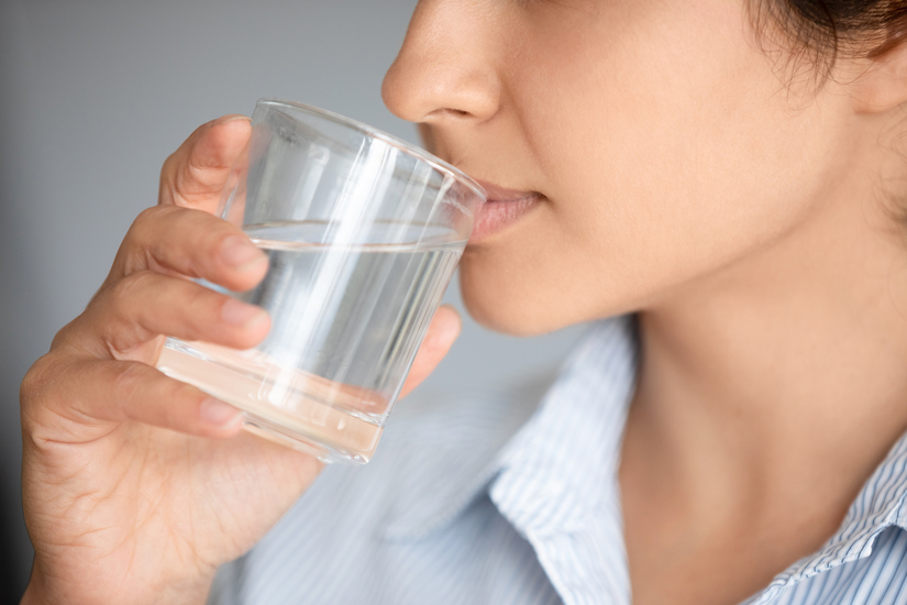 Close up cropped image girl hold glass drinks still aqua reduce thirst, daily caring about body water balance. Healthy life habit lifestyle and benefits, dehydration prevention, natural beauty concept