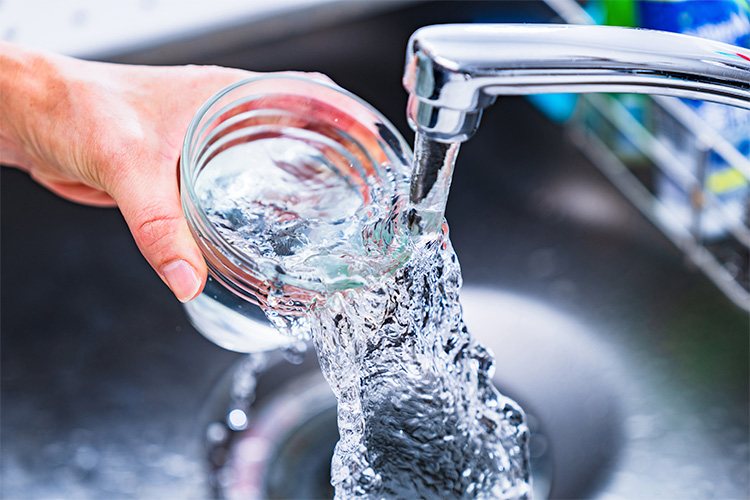 Person filling a cup with water