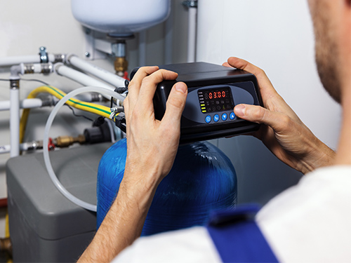 Technician programming a water softener system.